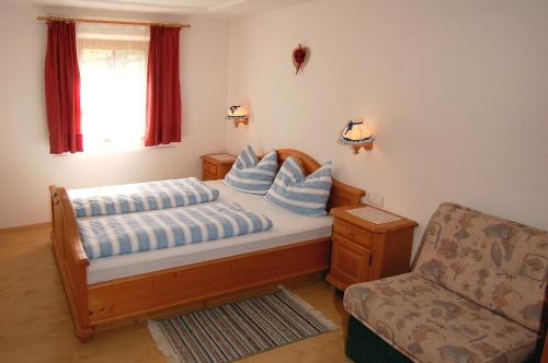 圣维吉利奥Vilahof的一间卧室配有一张带蓝色枕头的床和一把椅子
