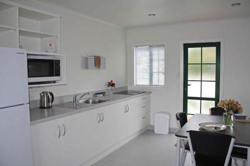 哈韦拉Kerry Lane Motel的白色的厨房配有水槽和桌子