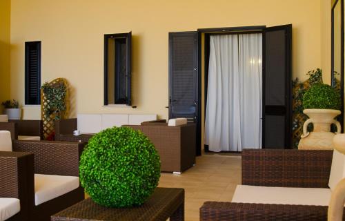 佩斯科勒海滨Hotel Salento Gold Beach的客厅配有棕色椅子和绿色灌木