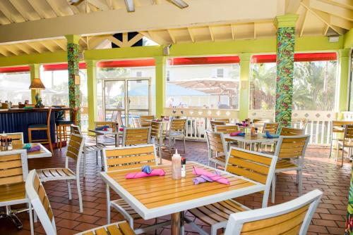 乔治敦阳光套房度假酒店的餐厅设有桌椅和窗户。