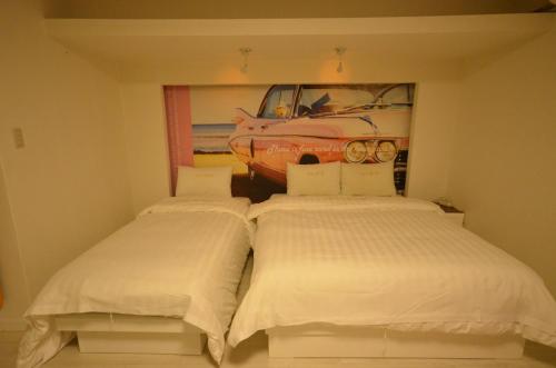 全州市全州舍利威尔汽车旅馆的墙上有一辆汽车,房间内设有两张床