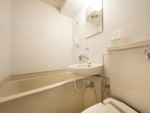 仙台绿色凉棚酒店的浴室配有盥洗盆、卫生间和浴缸。
