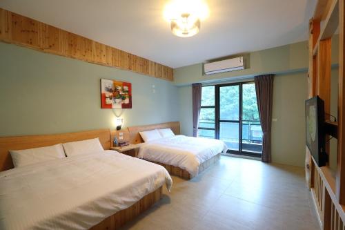 花莲市花莲夏朵民宿的酒店客房设有两张床和一台平面电视。