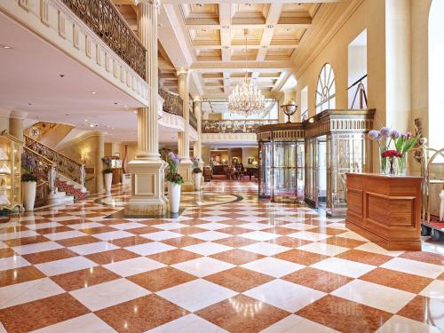 维也纳Grand Hotel Wien的大堂设有 ⁇ 形地板和吊灯
