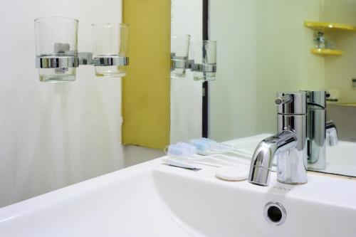 巴东巴东爱玛瑞斯酒店的浴室水槽设有水龙头和镜子