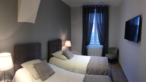 博讷Le Rendez Vous des Anges的一间卧室设有两张床和窗户。