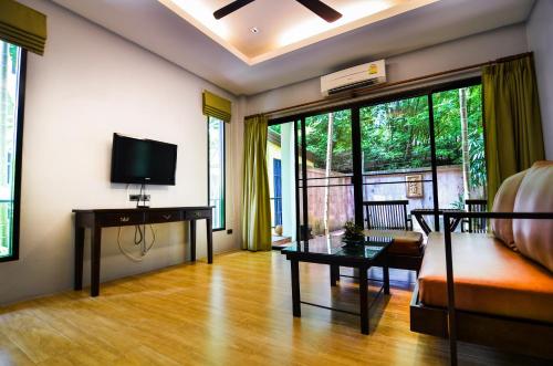 查龙Cocoville Phuket - SHA Plus的带沙发和电视的客厅
