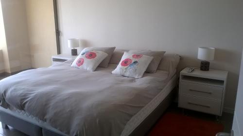 阿尔加罗沃Apartamentos Arenamaris的配有一张带两个枕头的白色床; 夜 ⁇ 
