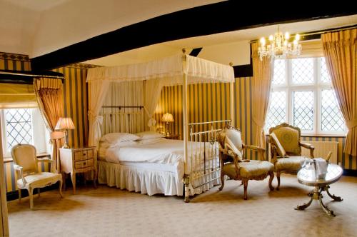 什鲁斯伯里Albright Hussey Manor的一间卧室配有一张天蓬床和两把椅子