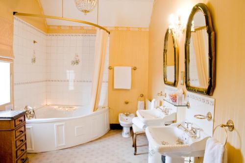 什鲁斯伯里Albright Hussey Manor的带浴缸、两个盥洗盆和浴缸的浴室。