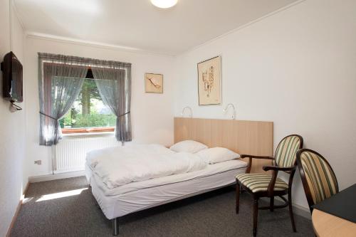 帕兹堡科若巴沃酒店的一间卧室配有一张床、一张桌子和一把椅子