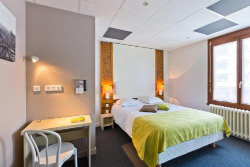 安锡Logis - Hôtel Restaurant Bellevue Annecy的配有一张床、一张桌子和一张桌子的酒店客房