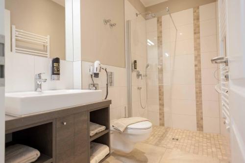 瓦尔内明德Ostseehotel Warnemünde的浴室配有卫生间、盥洗盆和淋浴。