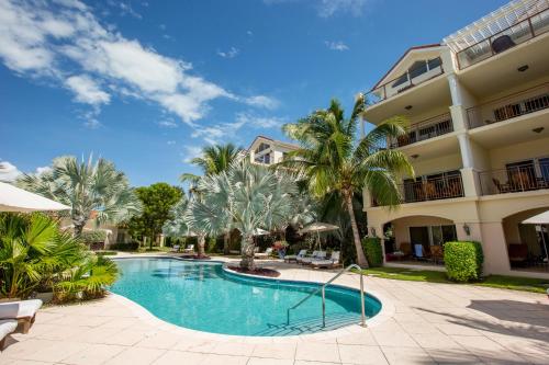 格雷斯湾德尔马尔别墅酒店的棕榈树建筑前的游泳池