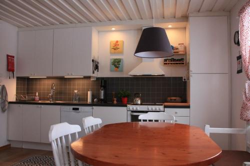 PuoltikasvaaraPuoltikasvaara 3的厨房配有木桌和白色橱柜。