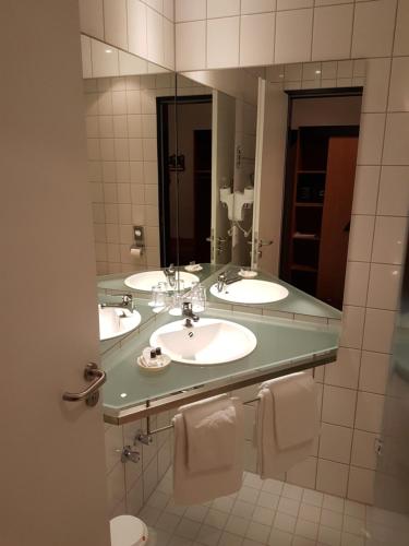伦格里希Hotel Zur Mühle的一间带两个盥洗盆和大镜子的浴室