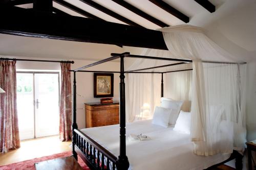 比达莱奥斯塔佩旅馆的一间卧室设有天蓬床和窗户。