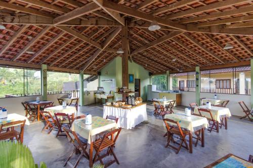 卡拉瓜塔图巴Viamar Pousada的餐厅设有桌椅和窗户。