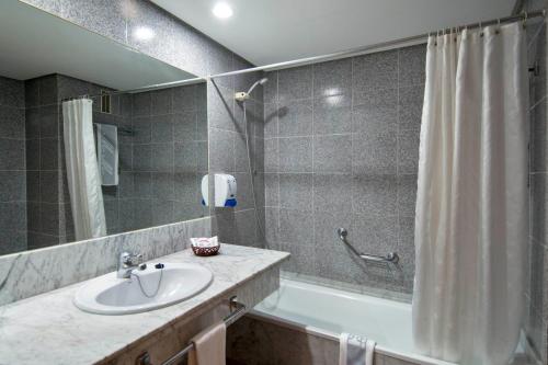 拉克鲁斯Hotel Puerto Palace的浴室配有盥洗盆和浴缸。