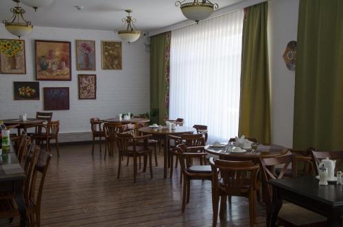 努库斯吉佩克漂亮酒店的一间带桌椅的用餐室和窗户。