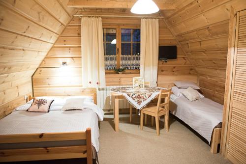 考斯赛力克Willa Jedlicka的小屋内设有一间带两张床和一张桌子的卧室