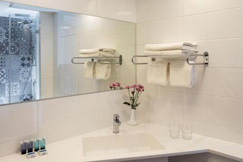 耶路撒冷七拱门酒店 的浴室配有盥洗盆、镜子和毛巾