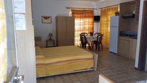 卡波利韦里Baia Azzurra的一间卧室配有一张床,厨房配有桌子