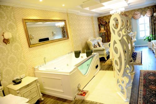 地拉那Hotel Britania的带浴缸和镜子的大浴室
