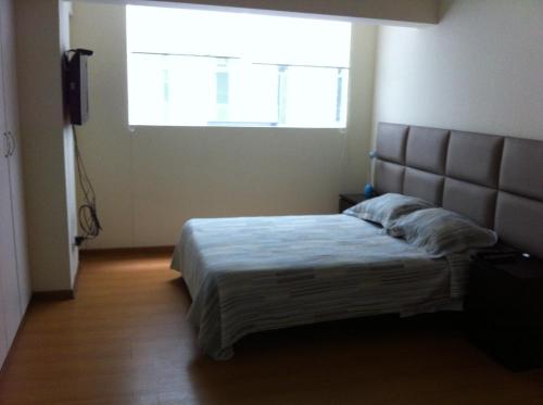 利马Departamento Miraflores的一间卧室设有一张大床和大窗户