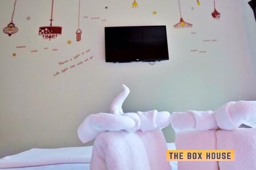 甲米镇博克斯之家度假村的一间卧室配有一张带玩具大象的床和一台电视机