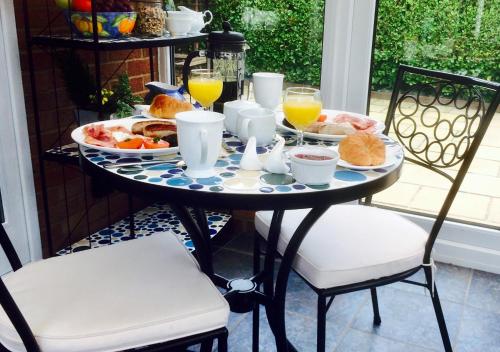 利明顿Stepping Stones B&B的早餐桌,包括早餐食品和橙汁
