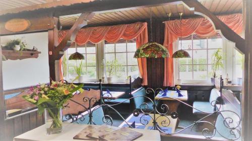 鲁尔河畔米尔海姆顿特内霍夫酒店的用餐室设有桌椅和窗户。