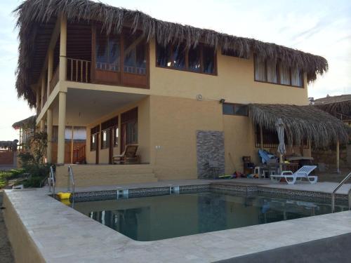 洛斯拉甘斯Villa Sunset Beach Peru的房屋前有游泳池的房子