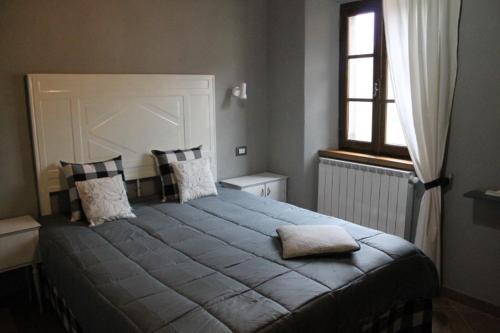 巴尼－迪卢卡Gombereto 10的卧室配有带枕头的大床和窗户。
