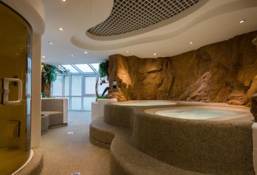 施瓦格明德福耳图那酒店的一间石墙内大浴室,配有浴缸