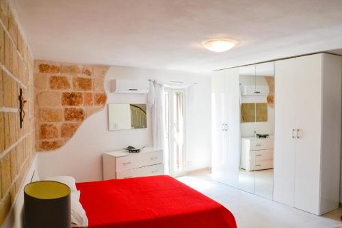 莫诺波利Dimora Arco Antico的一间卧室配有红色的床和镜子
