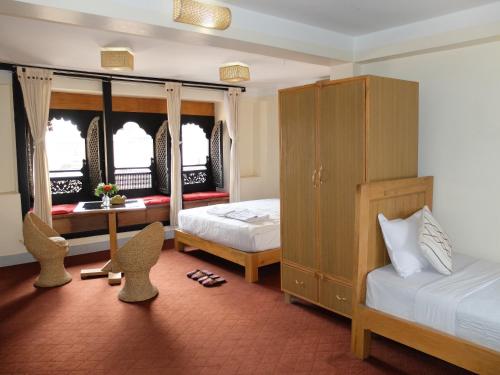 帕坦拉利特遗产住宿加早餐旅馆的一间卧室配有两张床和一张桌子及椅子