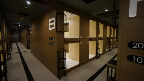 所泽市Spa胶囊旅馆（仅限男性）的大楼内带一排储物柜的走廊