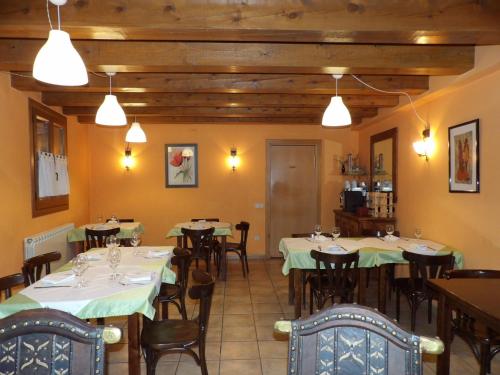 Durro奥德乡间旅馆的用餐室配有桌椅和灯光