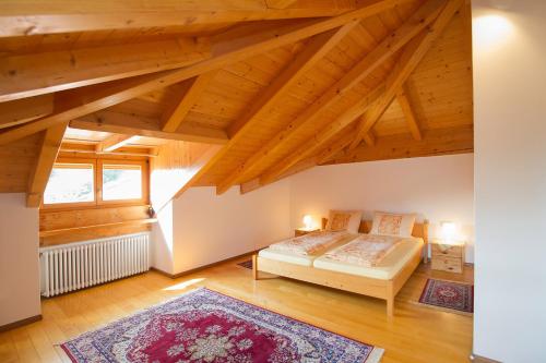 阿皮亚诺苏拉斯特拉达Tinnerhof的一间卧室设有床、窗户和木制天花板
