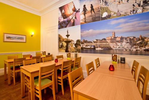 彭赞斯彭赞斯青年旅舍的餐厅设有桌椅,墙上挂着一幅大画
