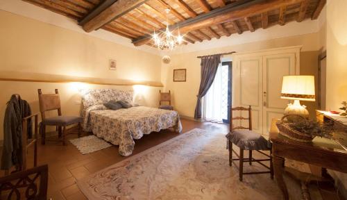 蒙泰斯佩尔托利Fattoria Poggio Capponi的卧室配有一张床和一张桌子及椅子
