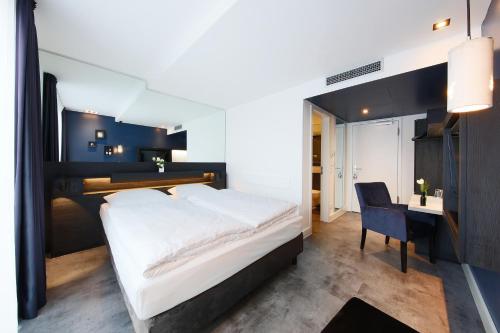 柏林林德曼酒店的一间卧室配有一张大床和一张书桌