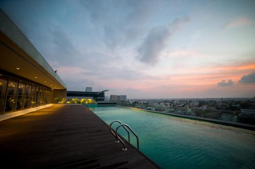钦奈钦奈馨香OMR酒店的一座享有日落美景的建筑屋顶上的游泳池