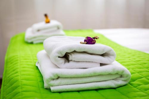 塞格德Aqualiget-Apartmanház的绿毯上的白色毛巾