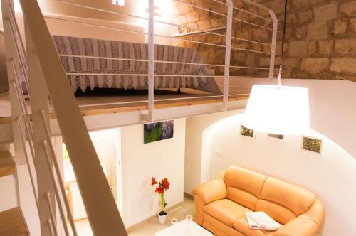 阿尔塔穆拉Murgia Dreams的一张位于小房间里高架床,配有沙发