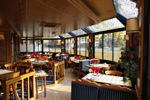阿尔让唐Le Refuge du P'tit Fischer的餐厅设有桌椅和窗户。