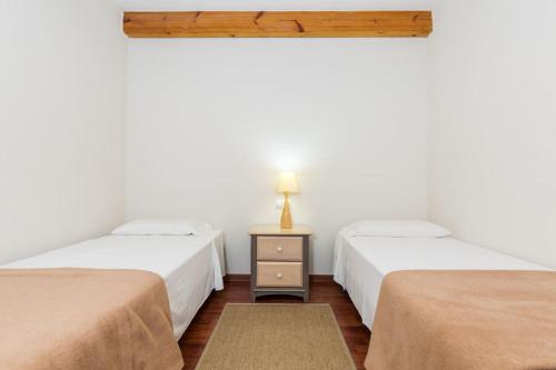 塞奥-德乌赫尔Cal Cinque的客房设有两张床和一张带台灯的桌子。