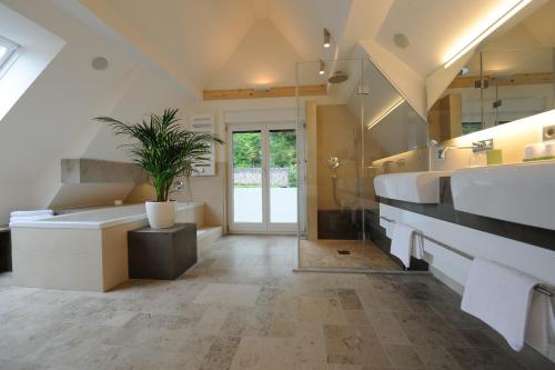 布尔雅格斯泰格酒店的浴室设有2个水槽、浴缸和植物