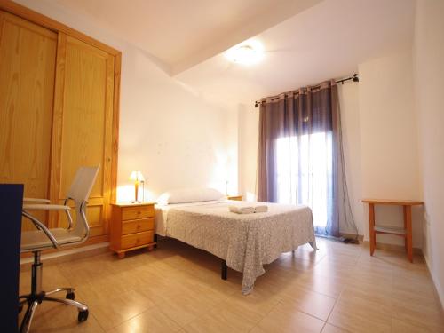 塔里法Livingtarifa Apartamento Blue II的一间卧室配有一张床、一个梳妆台和一扇窗户。